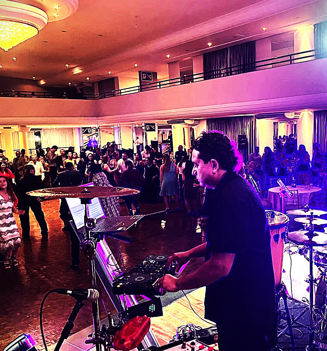 DJ Pulse performando em evento corporativo com público animado